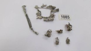 A silver charm bracelet with 11 charms, a silver chatelaine chain and 5 other silver charms,