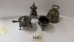 A silver plate 3 piece condiment set with blue glass liners and a brass bell.