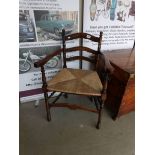 A 19th century country ladder back chair with rush seat on ringed turned legs,