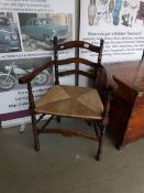 A 19th century country ladder back chair with rush seat on ringed turned legs,