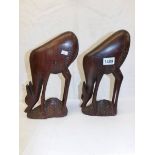 A pair of carved hard wood deer.