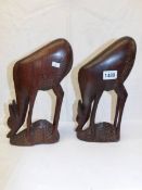 A pair of carved hard wood deer.