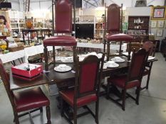 A long dark oak draw leaf table and 6 chairs with red leather panels (collect only).
