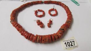 A coral necklace and 2 pairs of coral earrings.
