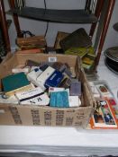 A box of tobacco/cigarette tins, cigarette packets and some cards.