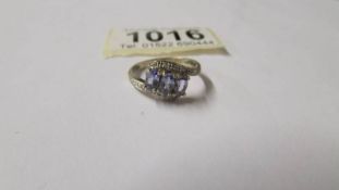 A diamond and tanzanite three stone ring with diamond shoulders in 9ct gold. Size N.