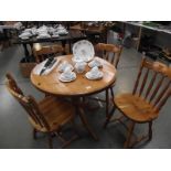 A solid pine circular kitchen table with 4 chairs.