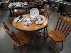 A solid pine circular kitchen table with 4 chairs.