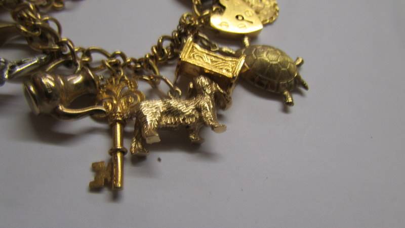 A 9ct gold charm bracelet with charms, 34 grams. (re-entered due to non paying bidder). - Image 3 of 4