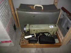 A cased electric MSN sewing machine on wooden base