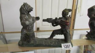 A rare cast iron money bank in the form of an American Indian shooting a bear.