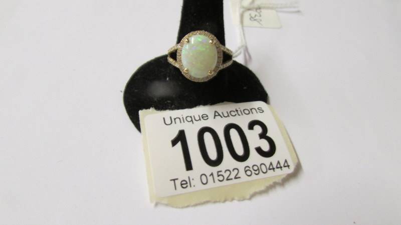A 14k gold ring set small diamonds and central opal (approx. 10mm x 12mm), size N.