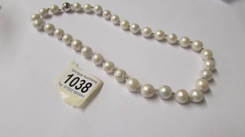 A substantial freshwater pearl necklace with silver ball clasp.