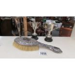 A silver backed hair brush, a silver spill vase and 2 silver trophies.