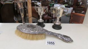 A silver backed hair brush, a silver spill vase and 2 silver trophies.