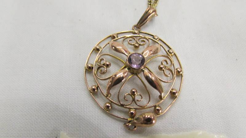 A gold pendant set amethyst on a yellow metal chain. - Image 2 of 2