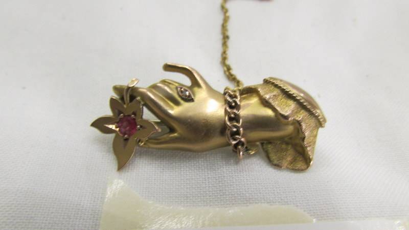 A gold brooch in the shape of a hand with safety chain. - Image 2 of 3