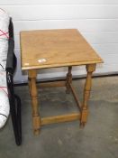 A polished light oak side table.