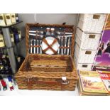 A picnic basket with contents and a 4 drawer wicker chest.