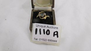 A gold ring (hall mark indistinct but possibly 18ct) set central blue stone and 2 small diamonds,