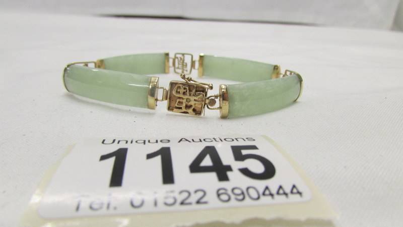 A gold Chinese bracelet with jade inserts stamped 9ct gold.