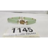 A gold Chinese bracelet with jade inserts stamped 9ct gold.