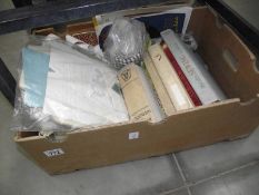 A box of fabric, haberdashery items and sewing/textile books.