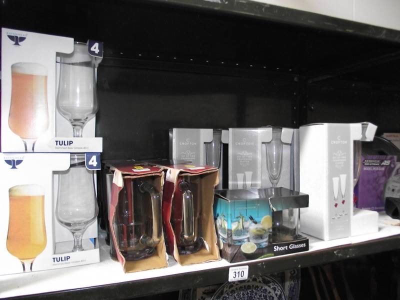 A shelf of boxed sets of drinking glasses.