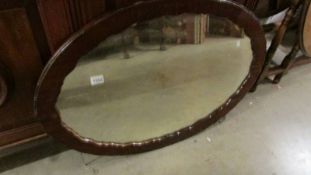 An oval framed mirror.