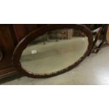 An oval framed mirror.