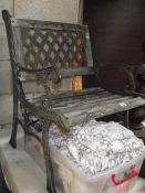 A cast iron single seat garden bench.