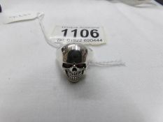 A silver skull ring with red eyes. Marked 925, size O.