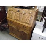 A panelled oak bureau.