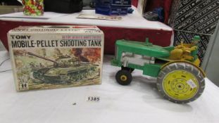 A boxed 'Tomy' battery operate plastic pellet shooting tanks and a battery operated plastic and tin