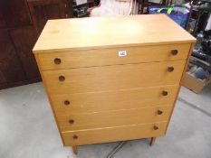 A teak veneered chest of drawers.