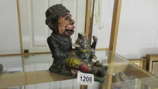 A rare cast iron money bank in the form of a policeman apprehending a pig.