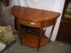 A light mahogany finished D end hall table with drawer and shelf.