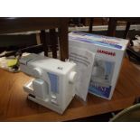 A boxed Janome mini sewing machine.