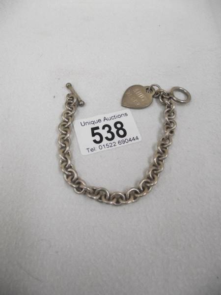 A silver heart (bracelet) on a metal bracelet.