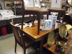 A teak extending dining table and 4 chairs.