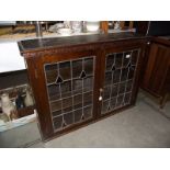 A 1930's oak 2 door display cabinet with leaded glass doors.