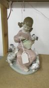 A Lladro figurine of a girl with puppies.
