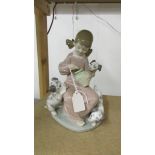 A Lladro figurine of a girl with puppies.