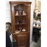 A dark pine corner cupboard.