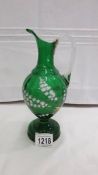 A 19th century green glass jug decorated with lily of the valley.