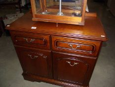 A dark wood stained wall cupboard with drawer.