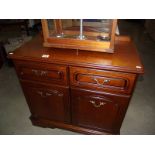 A dark wood stained wall cupboard with drawer.