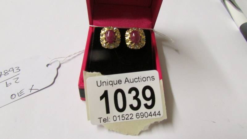 A pair of yellow gold ruby and diamond cluster earrings with screw backs.