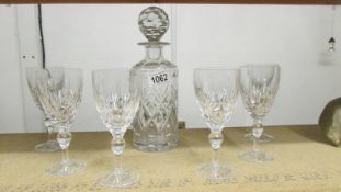 A cut glass decanter with 6 glasses.