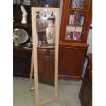 A lined oak effect floor standing mirror